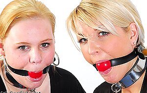Collared caucasian slaves are fitted with ball gags during non nude play